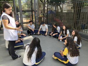 Crianças aprendendo em ambiente bilíngue com elementos das culturas brasileira e americana, promovendo a educação multiculturalismo na escola.